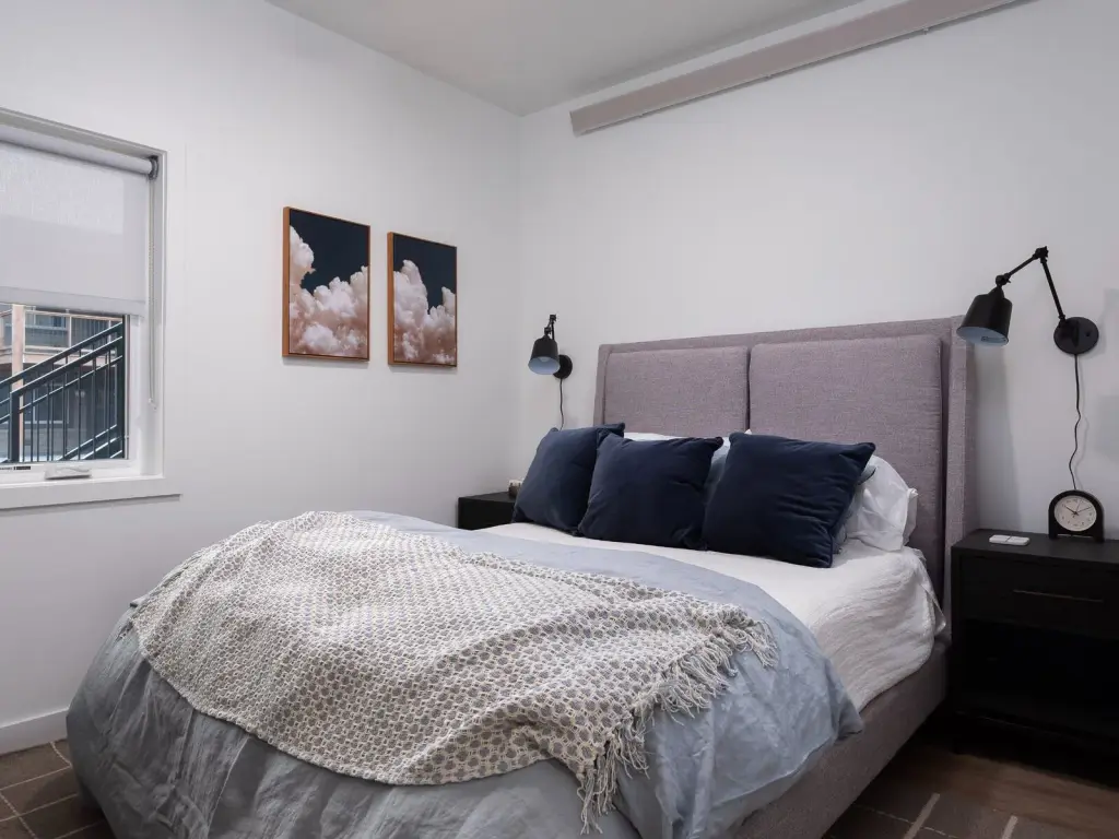 Staged one-bedroom model bedroom with a bed and nightstands